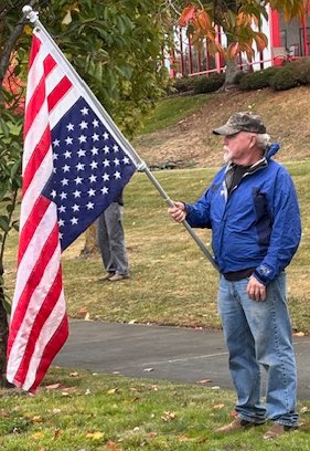man carrying upside down U S flag