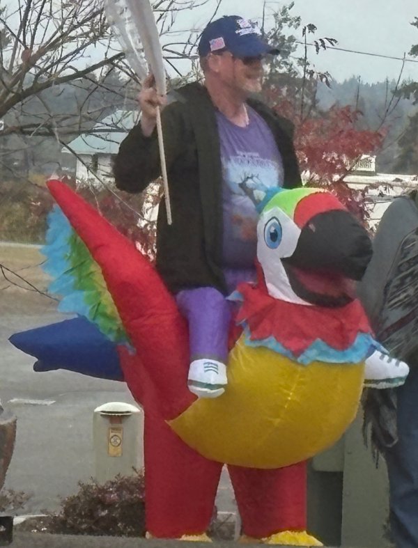 Man riding a blow up parrot